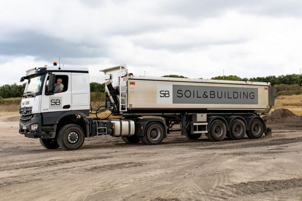 Vrachtwagen met oplegger van Soil & Building op de werf